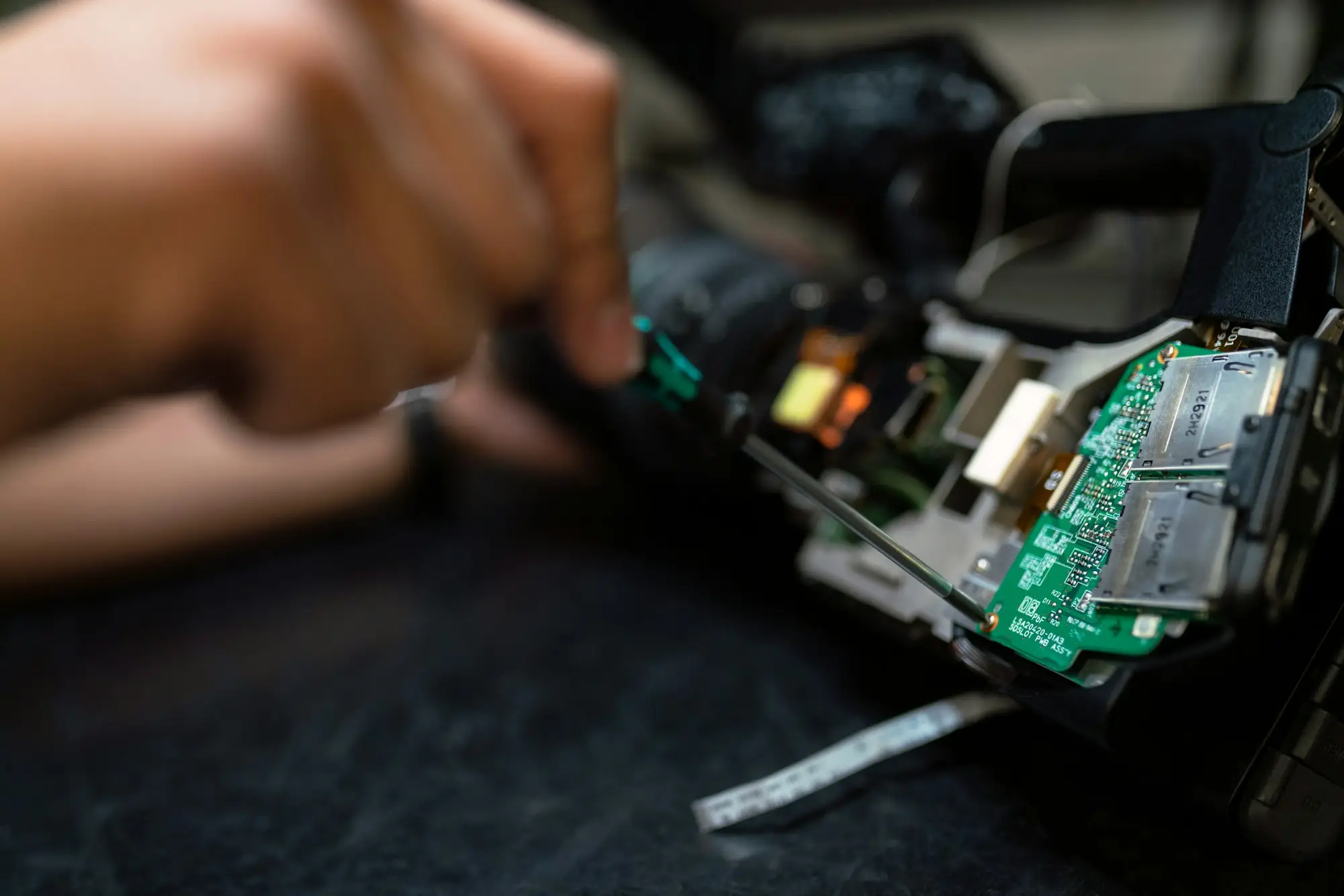 Mains gantées au travail sur une carte électronique, à l'établi